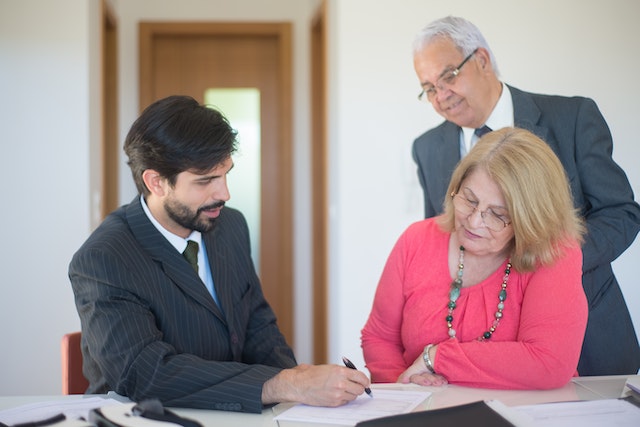 estate lawyer working on legally binding plan with elderly couple