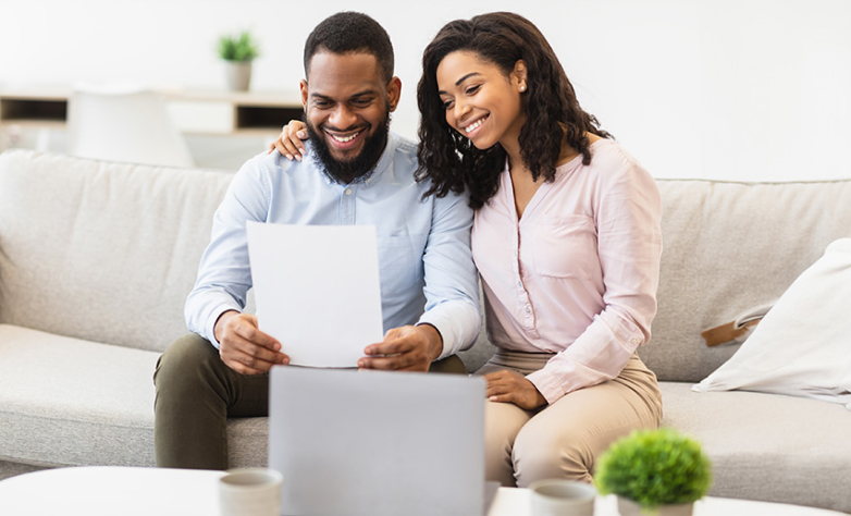 Positive black couple reading letter at home 1