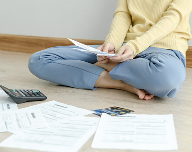 Stressed and headache asian woman with large bills 1