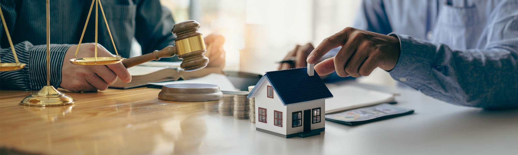 judge holding wooden judge hammer against house background