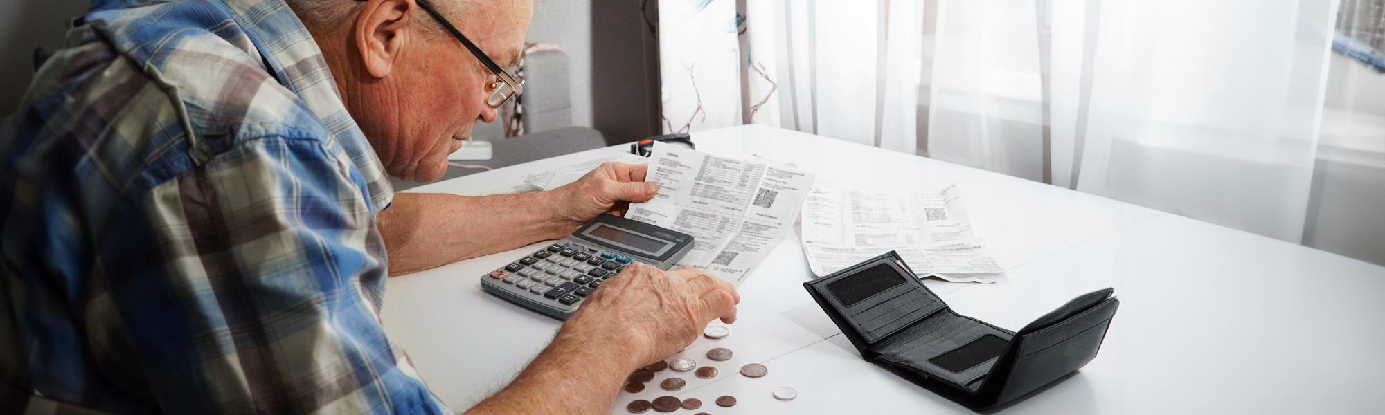 senior man sitting at the table and calculating finances