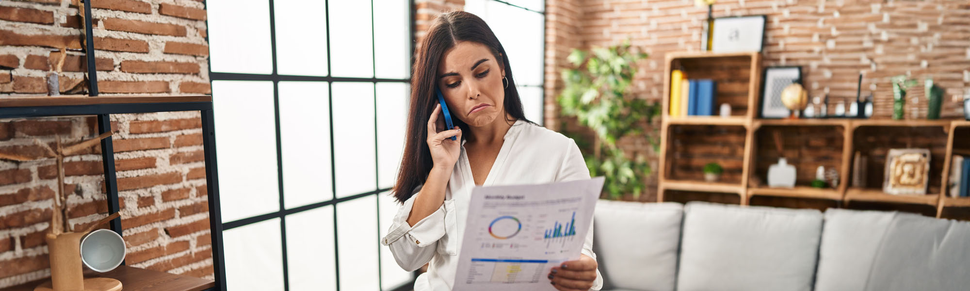 young hispanic woman speaking on the phone about bills