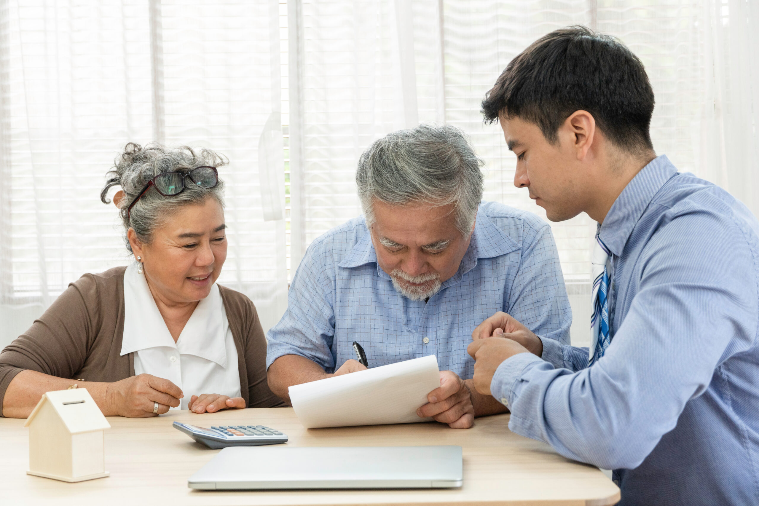 Asian senior man signing on agreement contract with supporting