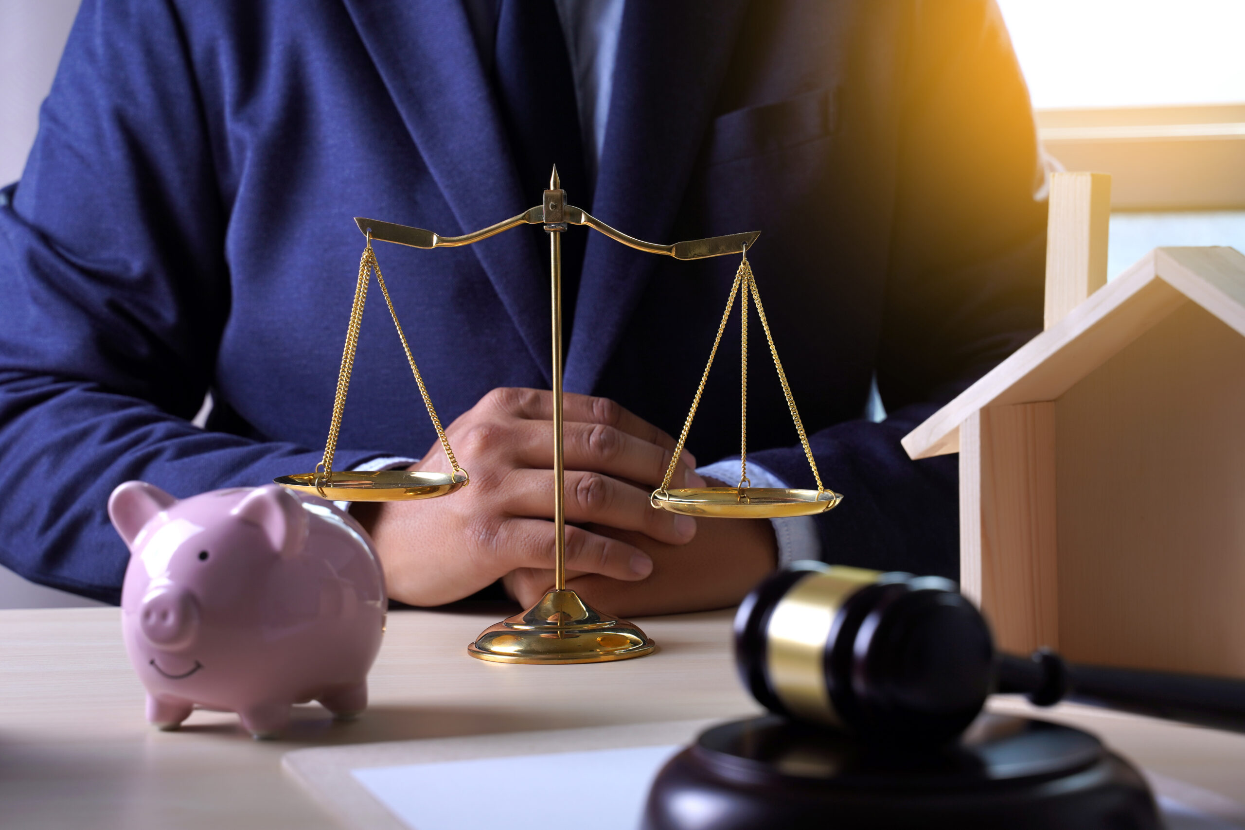 man with piggy bank gavel tiny wooden home lawyer