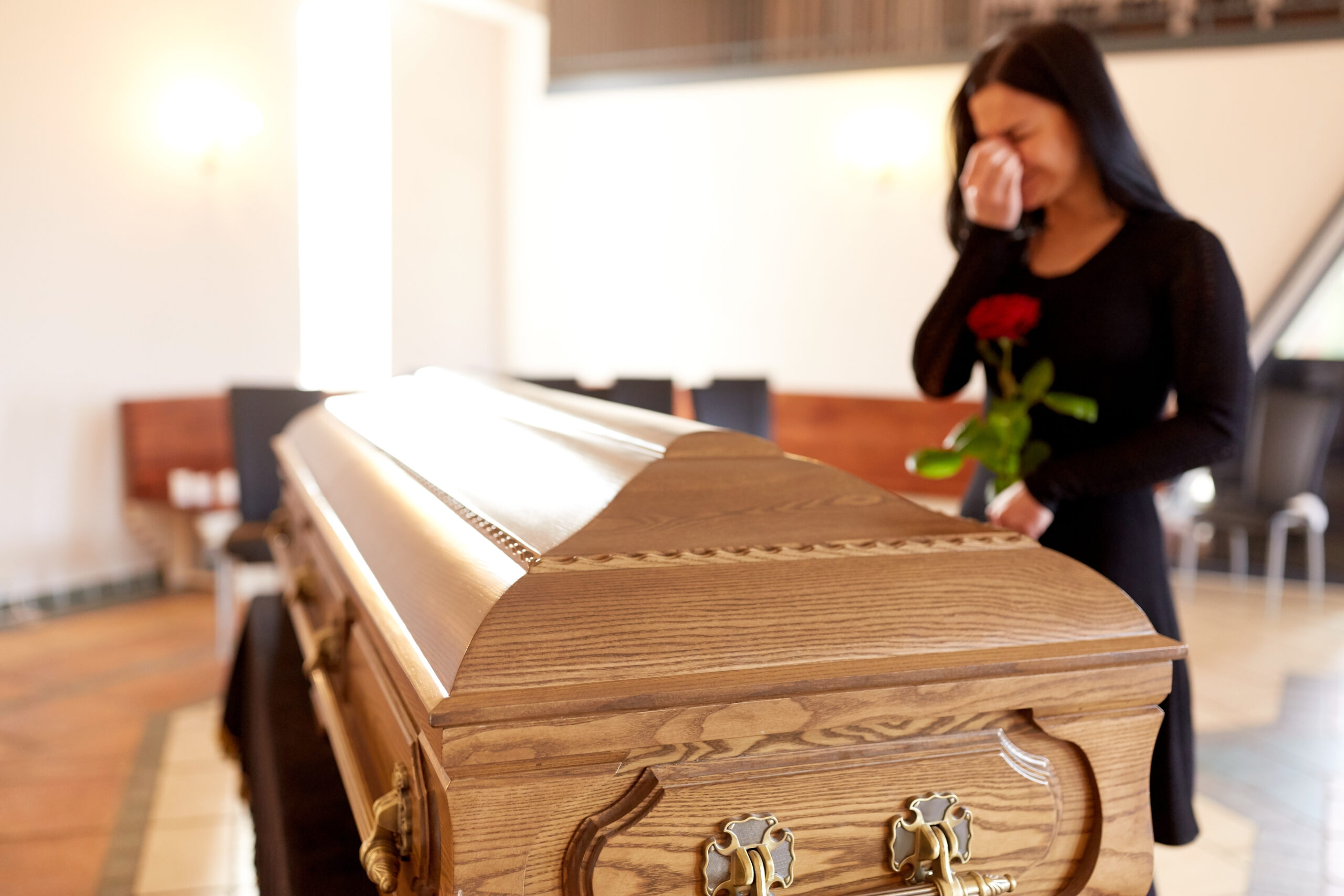 woman with coffin crying at funeral in church
