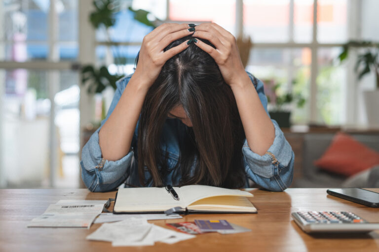 stressed woman accounting home expenses and calculate credit card monthly debt to bills payment.