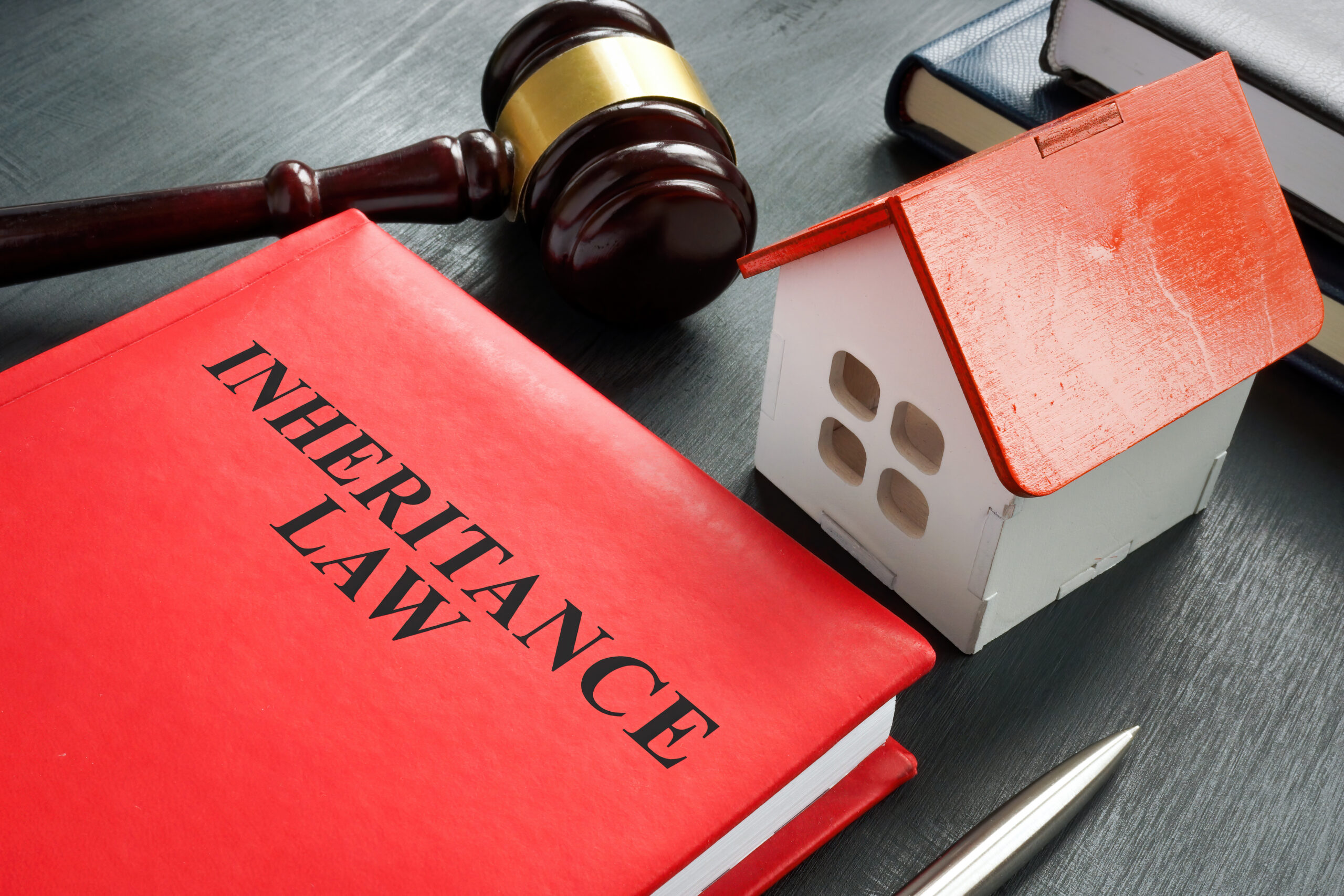 Inheritance law book, model of house and a gavel.