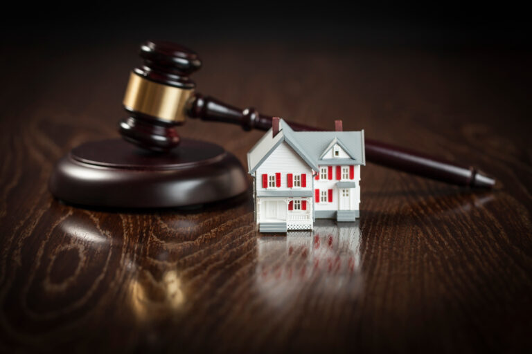 Gavel and Small Model House on Wooden Table.