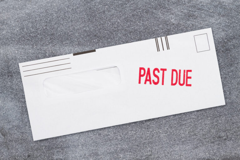 Past Due word message on business envelope on a weathered gray stone